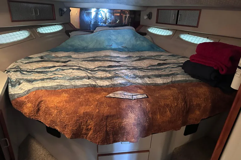 Slide: The Image of Interior cabin of 1989 Sea Ray 390 Express Cruiser with nautical-themed bedding. - 36