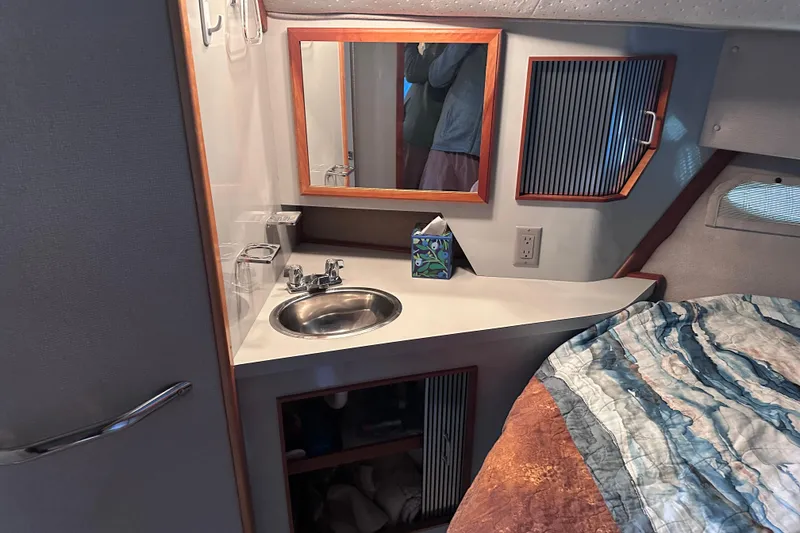 Slide: The Image of 1989 Sea Ray 390 Express Cruiser cabin with sink, mirror, and bed. - 37