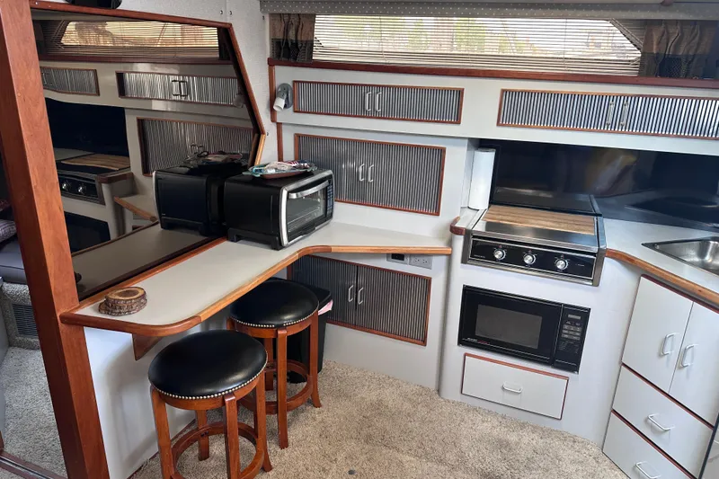 Slide: The Image of Interior of 1989 Sea Ray 390 Express Cruiser with kitchen and seating area. - 39