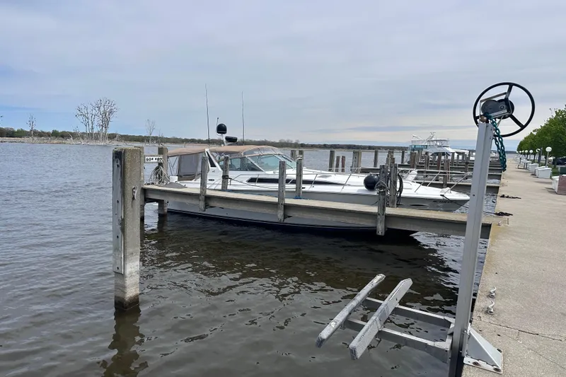 Slide: The Image of 1989 Sea Ray 390 Express Cruiser docked at a marina on a cloudy day. - 5