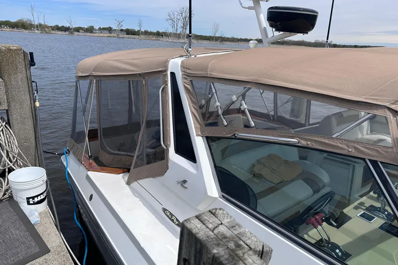 Slide: The Image of 1989 Sea Ray 390 Express Cruiser docked, featuring tan canopy and spacious interior. - 6