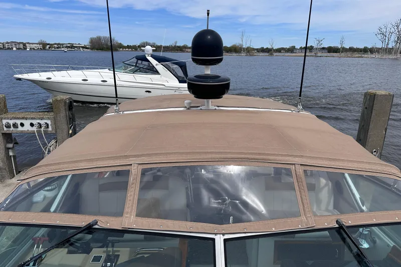 Slide: The Image of 1989 Sea Ray 390 Express Cruiser docked, with another boat passing by on a sunny day. - 7