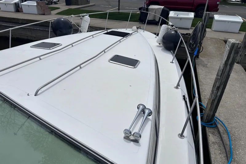 Slide: The Image of 1989 Sea Ray 390 Express Cruiser docked, showcasing sleek deck design and mooring equipment. - 8