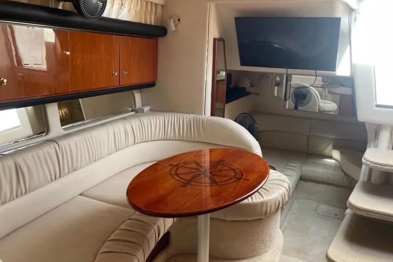 Slide: The Image of Interior of 2001 Sea Ray 340 Sundancer with plush seating and wooden table. - 2