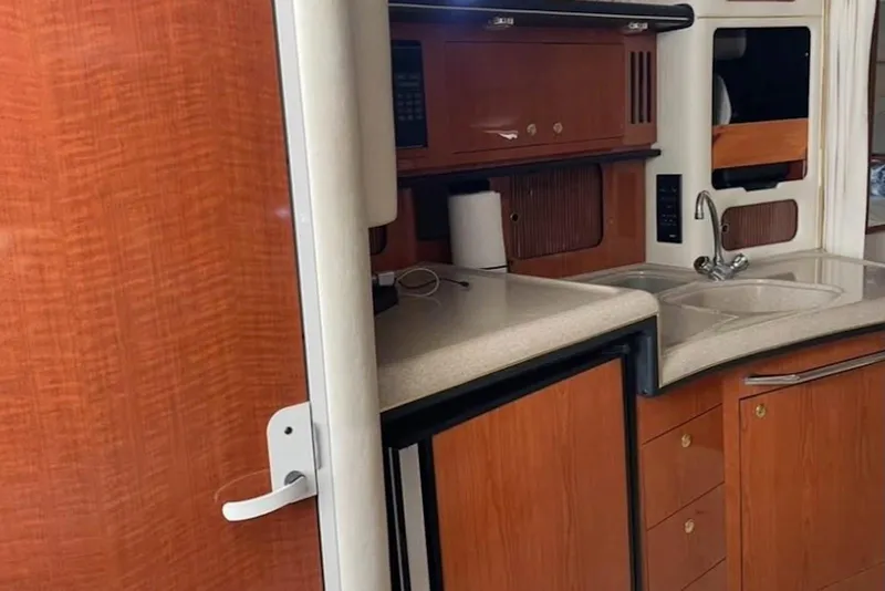 Slide: The Image of Interior of 2001 Sea Ray 340 Sundancer yacht, featuring a compact kitchen area. - 3