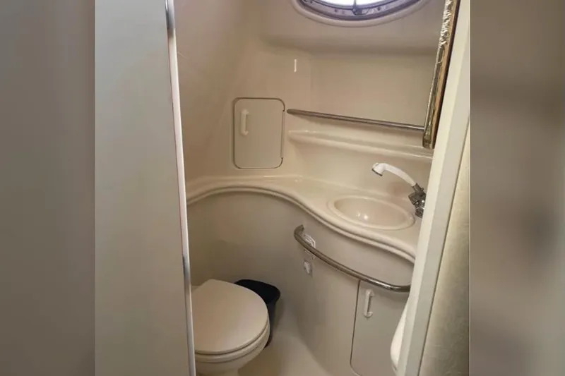Slide: The Image of Compact bathroom in a 2001 Sea Ray 340 Sundancer yacht, featuring a toilet and sink. - 5