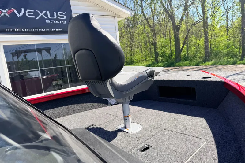 Slide: The Image of 2026 Crestliner 1650 Kodiak WT boat seat, outdoor setting, Vexus Boats sign in background. - 6