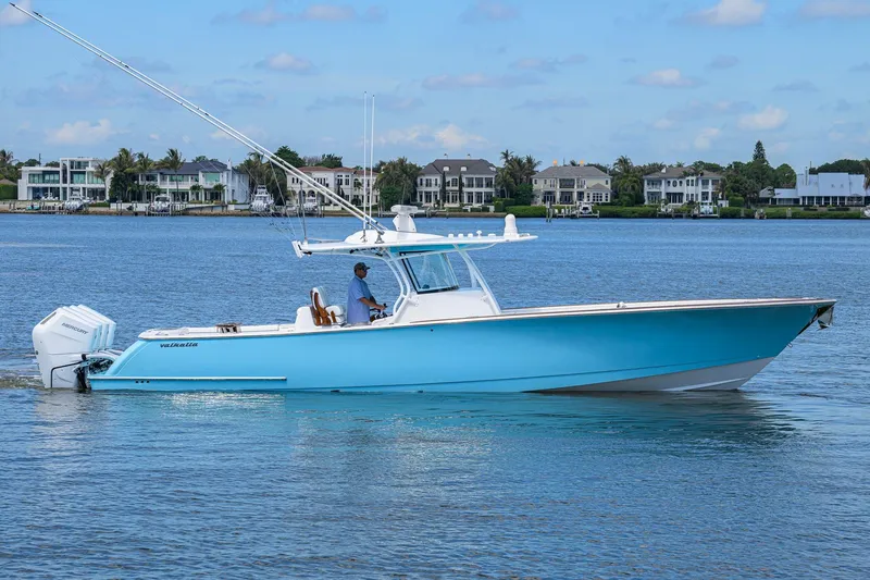 The Image of 2025 Valhalla Boatworks V-41 in blue, cruising on calm waters near luxury homes. - 0
