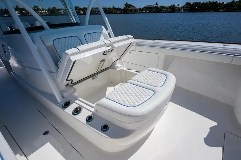 Slide: The Image of 2025 Valhalla Boatworks V-41 with open storage compartment, luxurious seating, and scenic water backdrop. - 21