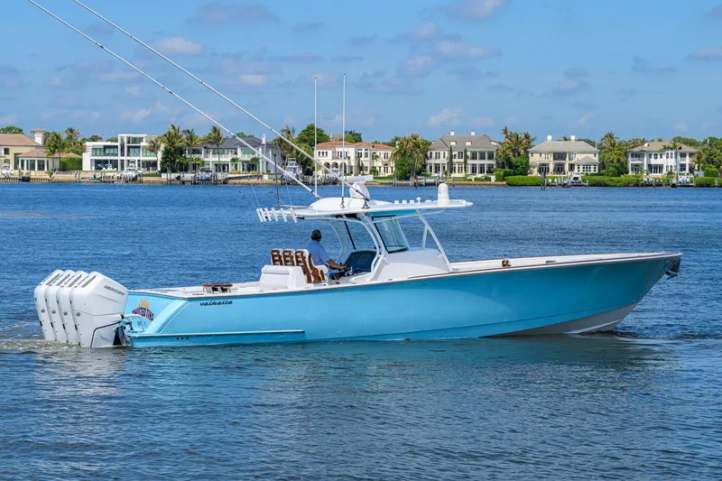 Slide: The Image of 2025 Valhalla Boatworks V-41 cruising on a scenic waterfront with luxury homes. - 3