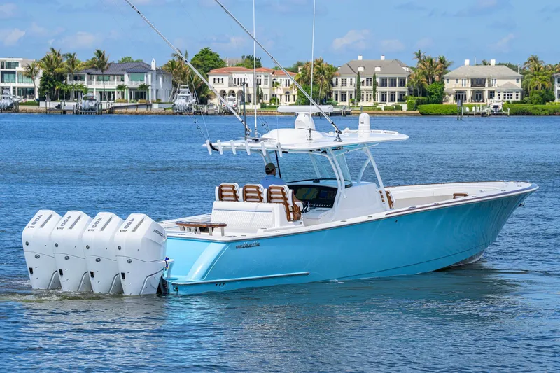 Slide: The Image of 2025 Valhalla Boatworks V-41 in blue, cruising on a scenic waterfront. - 4
