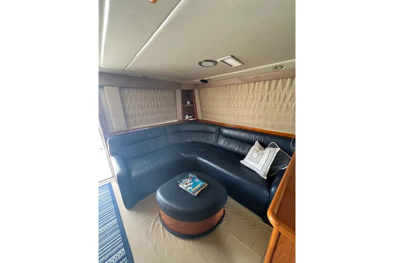 Slide: The Image of Luxurious interior of 2002 Riviera 54 Enclosed Flybridge with leather seating and ottoman. - 10