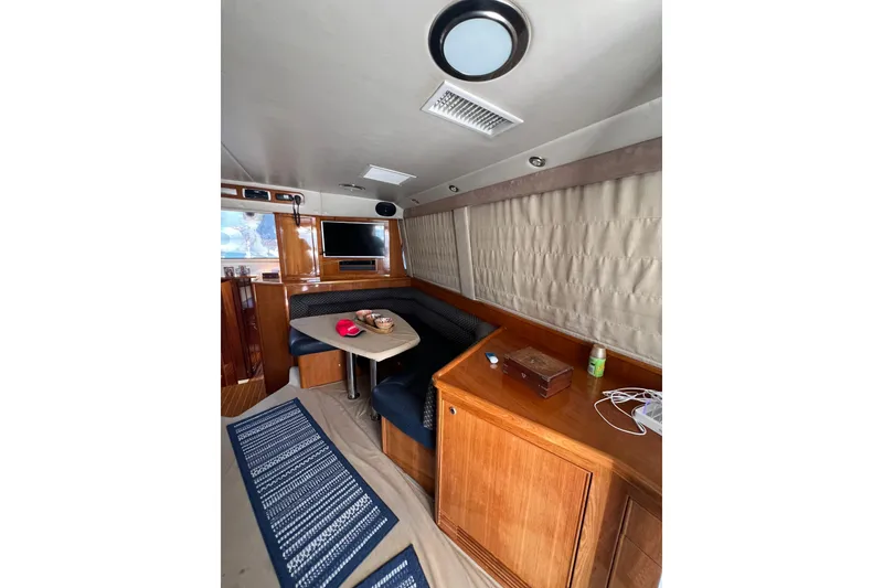 Slide: The Image of Interior of 2002 Riviera 54 Enclosed Flybridge with seating, table, and TV. - 12