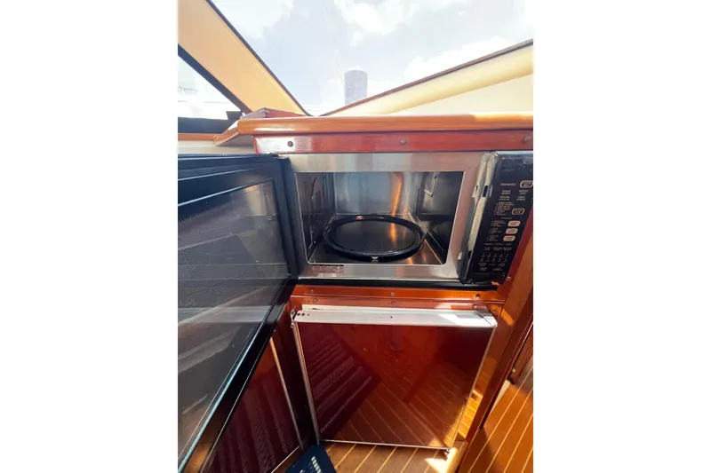Slide: The Image of Microwave and fridge in 2002 Riviera 54 Enclosed Flybridge yacht kitchen. - 16