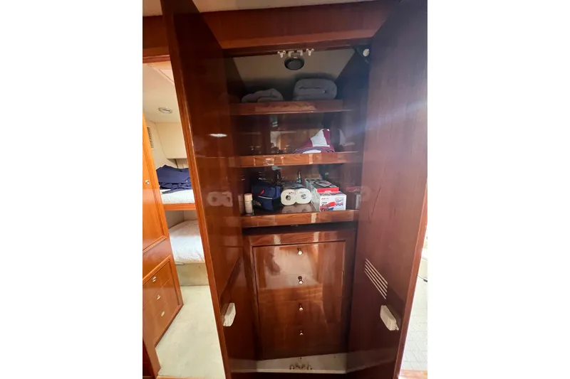 Slide: The Image of Interior storage cabinet on 2002 Riviera 54 Enclosed Flybridge yacht with shelves and supplies. - 19