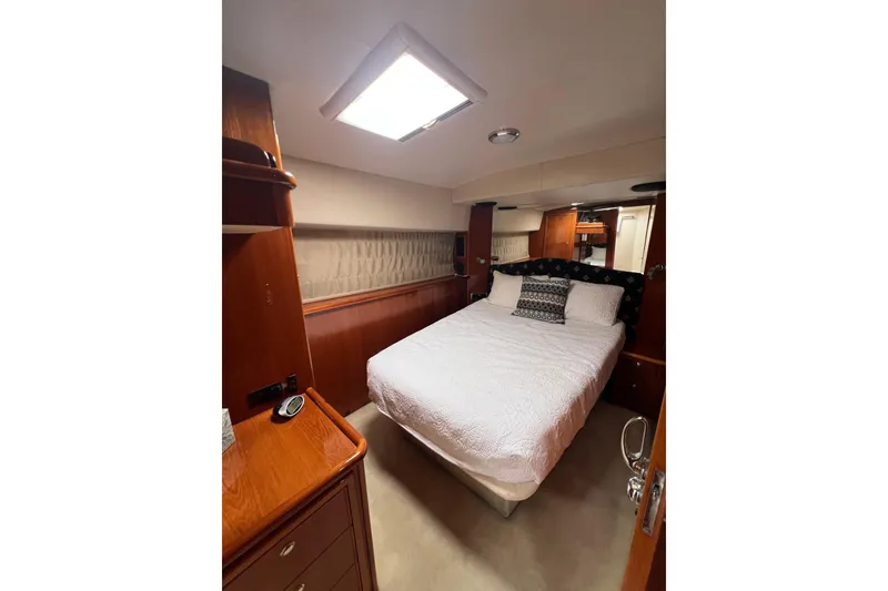 Slide: The Image of Luxurious bedroom interior of 2002 Riviera 54 Enclosed Flybridge yacht with elegant wood finishes. - 20