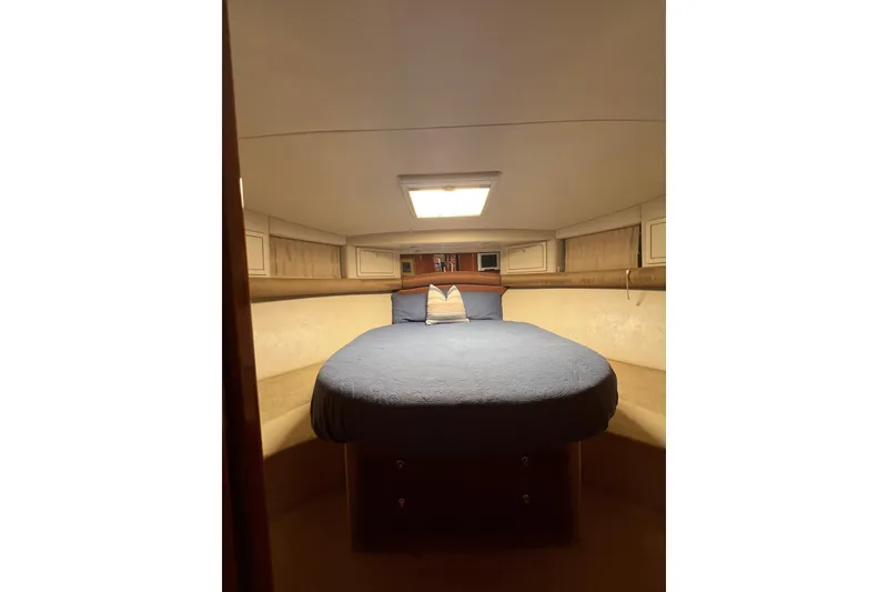 Slide: The Image of Cozy bedroom interior of 2002 Riviera 54 Enclosed Flybridge yacht with blue bedding. - 21
