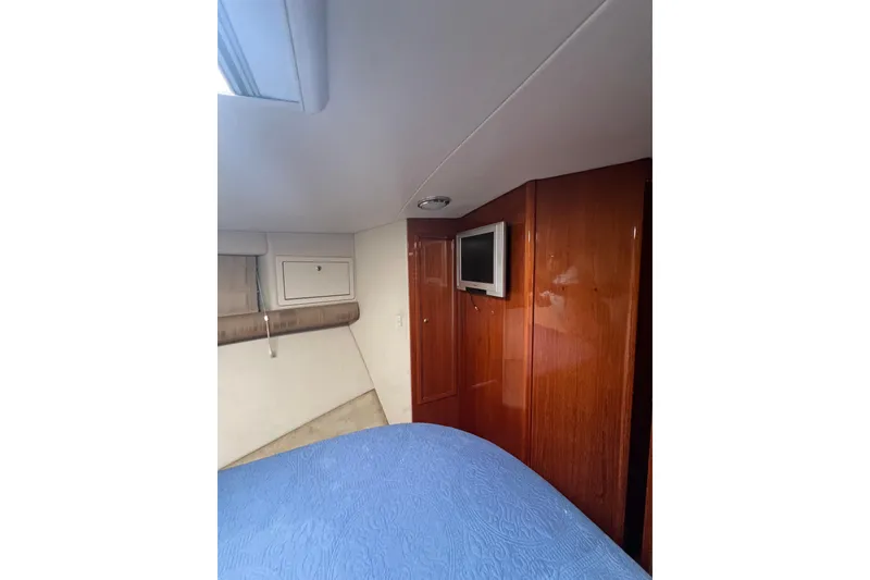 Slide: The Image of Interior cabin of 2002 Riviera 54 Enclosed Flybridge with wood paneling and TV. - 22