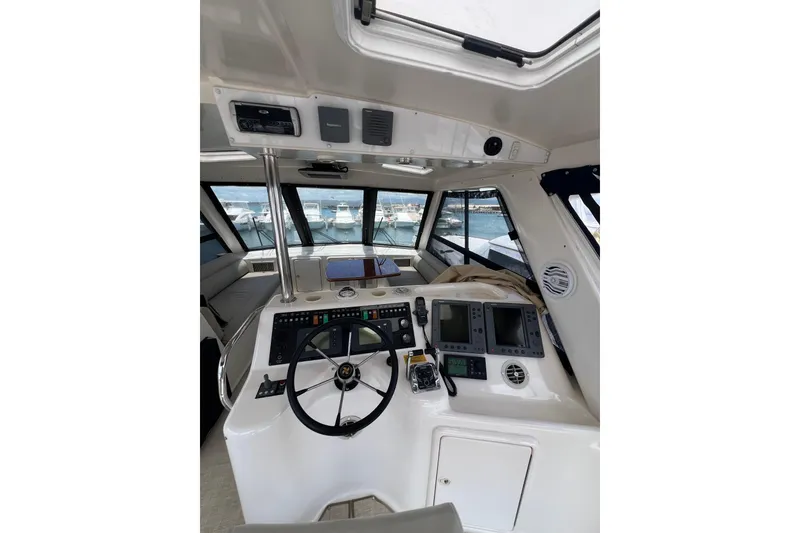 Slide: The Image of 2002 Riviera 54 Enclosed Flybridge helm with steering wheel and navigation equipment. - 26