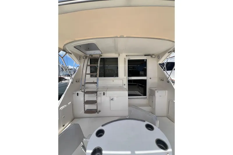 Slide: The Image of 2002 Riviera 54 Enclosed Flybridge yacht interior with ladder and seating area. - 3