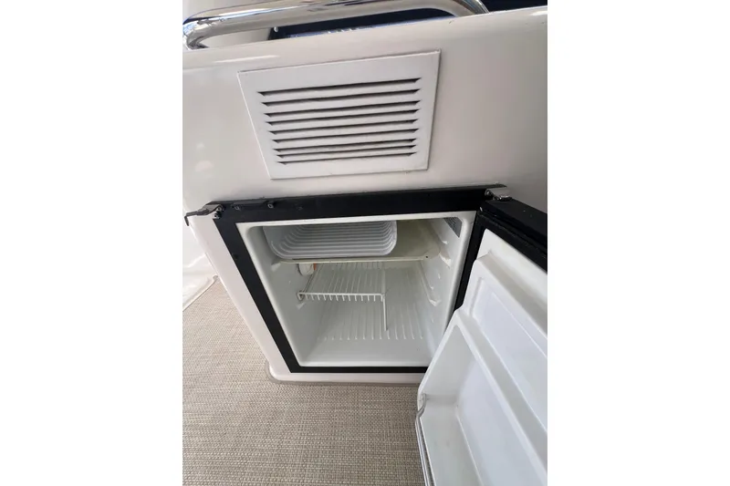 Slide: The Image of Open mini fridge on 2002 Riviera 54 Enclosed Flybridge yacht, showcasing interior storage space. - 32