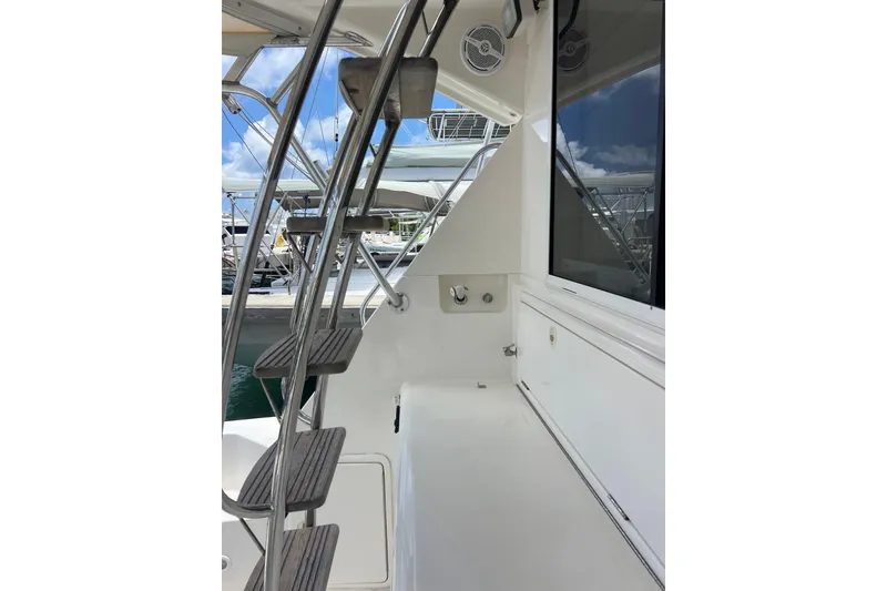 Slide: The Image of 2002 Riviera 54 Enclosed Flybridge yacht with stainless steel ladder and sleek white deck. - 4