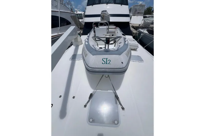 Slide: The Image of 2002 Riviera 54 Enclosed Flybridge yacht with inflatable tender on deck. - 5