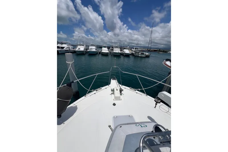 Slide: The Image of Bow view of 2002 Riviera 54 Enclosed Flybridge yacht in marina, under blue sky. - 6