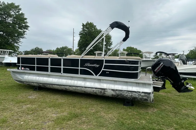 Slide: The Image of 2021 Bentley Pontoons 240 CRUISE on grass, featuring a Mercury outboard motor. - 2