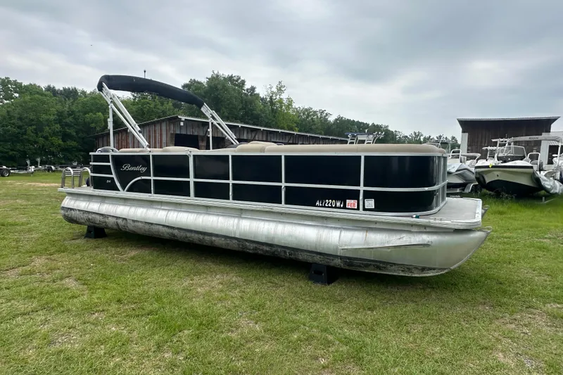 Slide: The Image of 2021 Bentley Pontoons 240 CRUISE pontoon boat on grassy area, overcast sky. - 7