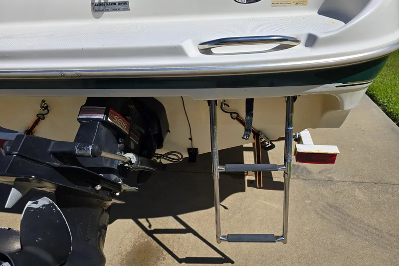 Slide: The Image of 1999 Bayliner 1850 Capri SS boat stern with ladder and outboard motor. - 10