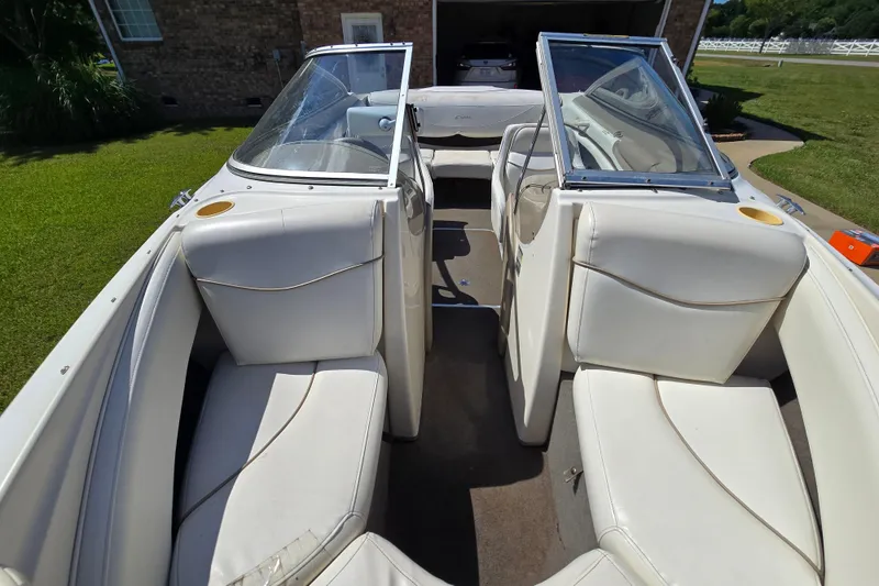 Slide: The Image of 1999 Bayliner 1850 Capri SS boat interior with white seating and open windshield. - 18