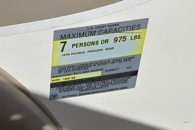 Slide: The Image of Sticker on 1999 Bayliner 1850 Capri SS showing maximum capacity of 7 persons or 975 lbs. - 24
