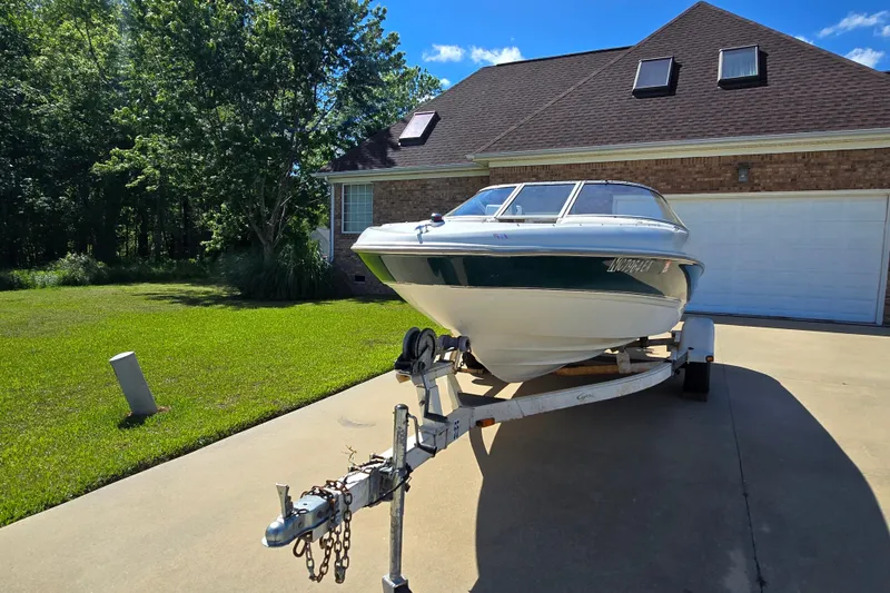 Slide: The Image of 1999 Bayliner 1850 Capri SS boat on trailer, parked in driveway near house. - 29