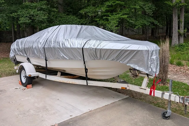 Slide: The Image of Covered 1999 Bayliner 1850 Capri SS boat on trailer, parked on concrete driveway. - 3