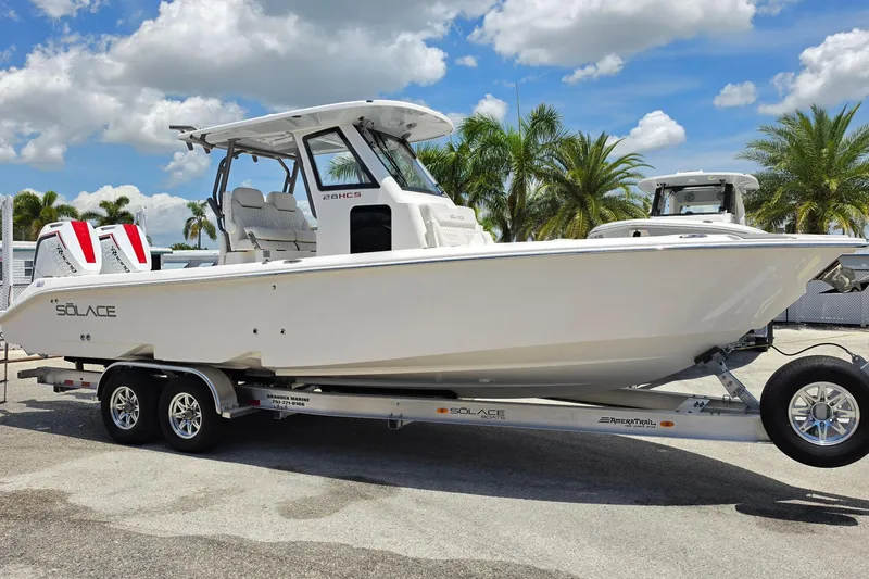 The Image of 2026 Solace 28HCS boat on trailer, parked outdoors under a blue sky. - 0