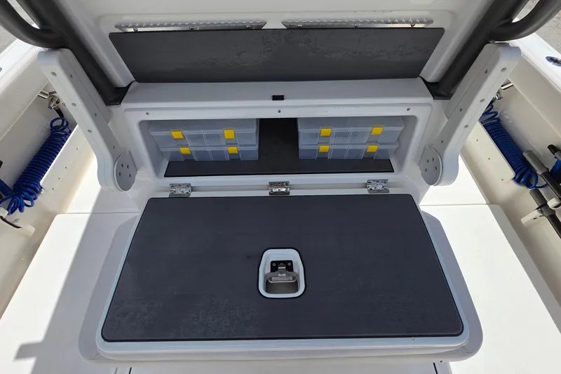 Slide: The Image of Storage compartment on a 2026 Solace 28HCS boat, featuring organized tackle boxes. - 10