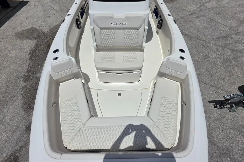 Slide: The Image of 2026 Solace 28HCS boat interior with white cushioned seating and diamond stitching. - 21