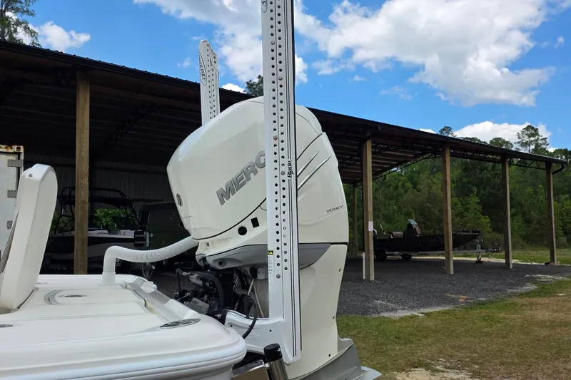 Slide: The Image of 2018 SeaVee 270Z boat with Mercury engine, parked near a covered structure under a blue sky. - 10