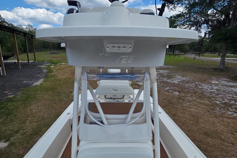 Slide: The Image of 2018 SeaVee 270Z boat with elevated helm station, parked on grassy area under blue sky. - 3