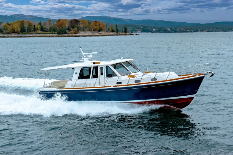 The Image of 2014 Grand Banks 46 Eastbay SX cruising on a scenic lake with autumn foliage. - 0