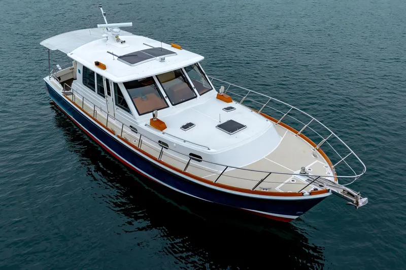Slide: The Image of 2014 Grand Banks 46 Eastbay SX yacht on calm water, showcasing sleek design and luxury features. - 10
