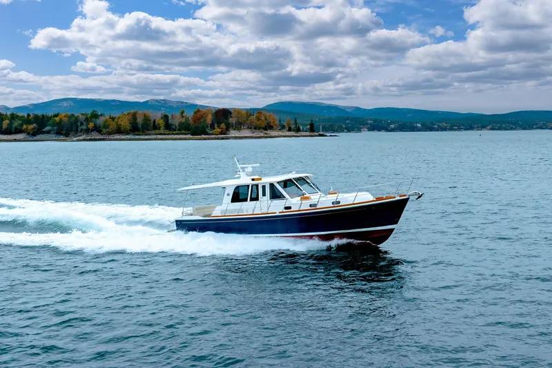 Slide: The Image of 2014 Grand Banks 46 Eastbay SX cruising on a scenic lake with mountains in the background. - 11