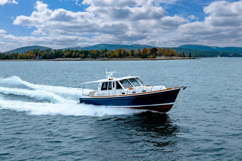 Slide: The Image of 2014 Grand Banks 46 Eastbay SX cruising on a scenic lake with forested hills. - 12