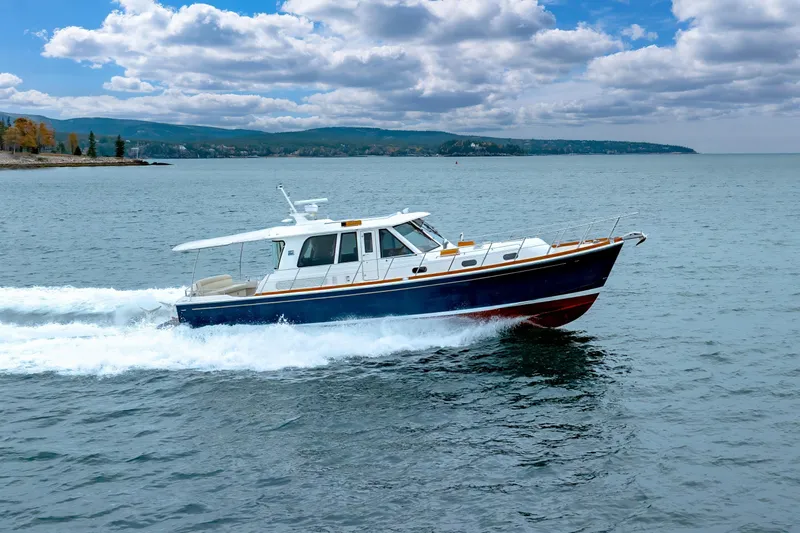 Slide: The Image of 2014 Grand Banks 46 Eastbay SX cruising on open water under a cloudy sky. - 13