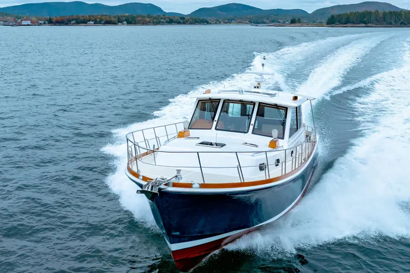 Slide: The Image of 2014 Grand Banks 46 Eastbay SX cruising on open water with scenic mountain backdrop. - 15