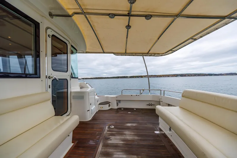 Slide: The Image of 2014 Grand Banks 46 Eastbay SX yacht deck with seating, overlooking calm waters. - 20