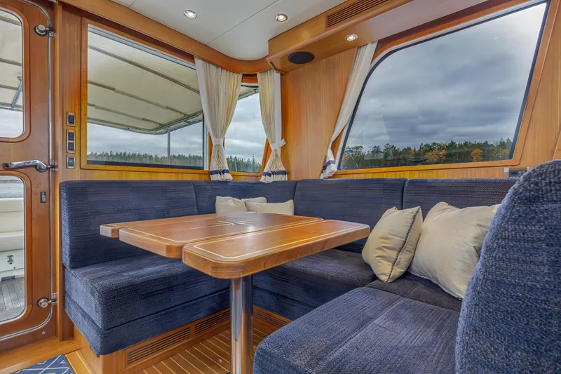 Slide: The Image of Luxurious 2014 Grand Banks 46 Eastbay SX yacht interior with plush seating and wooden table. - 30
