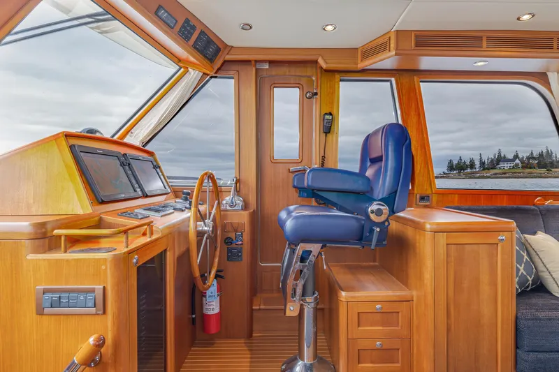 Slide: The Image of Interior helm of 2014 Grand Banks 46 Eastbay SX with wooden finish and blue captain's chair. - 39