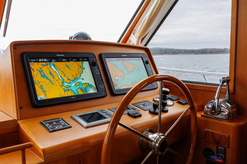 Slide: The Image of Helm of 2014 Grand Banks 46 Eastbay SX with navigation screens and wooden steering wheel. - 41